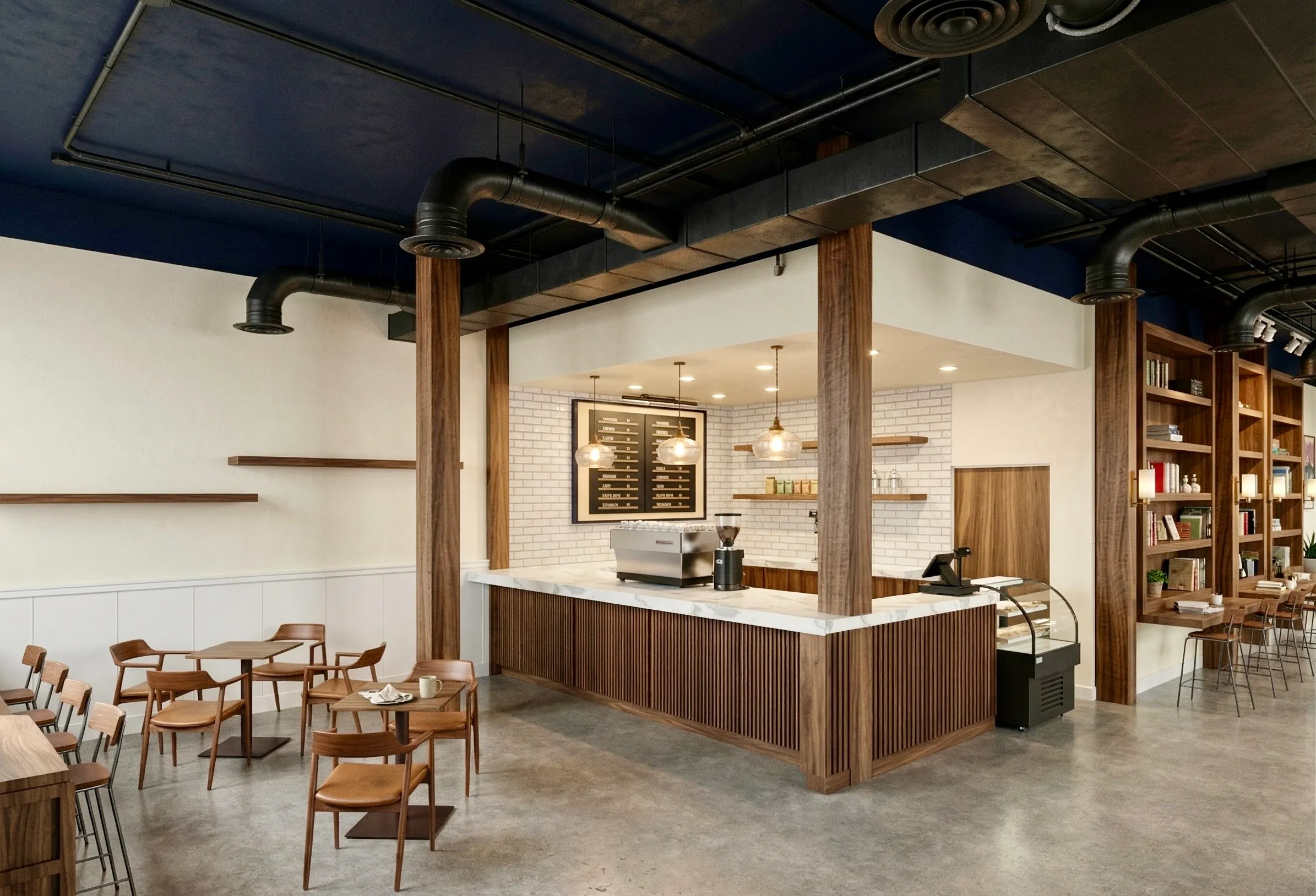 The Bayit Brew espresso bar — walnut counter, white subway tile, copper pendant lights, and a deep navy ceiling with exposed ductwork.